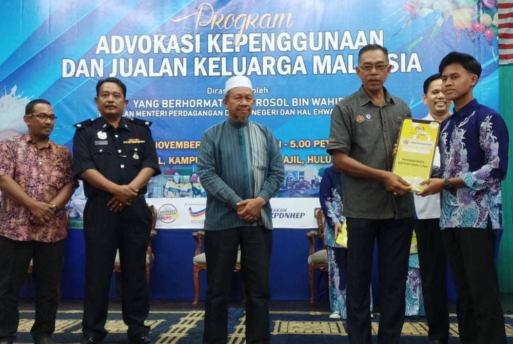 Rosol (dua dari kanan) menyampaikan Bantuan Rintis Tanpa Tunai melalui e-dompet kepada salah seorang pelajar Tingkatan Enam pada Khamis.