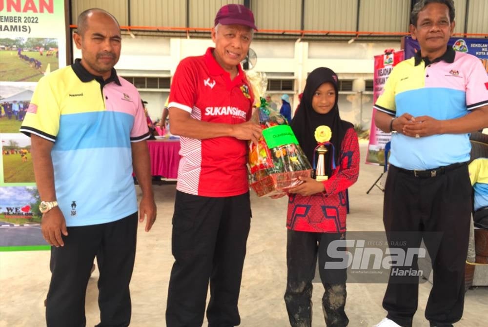 Muhammad Nasir (dua dari kiri) diiringi Azmi (kanan) menyampaikan hadiah kepada Nur Danisha Izara (dua dari kanan).