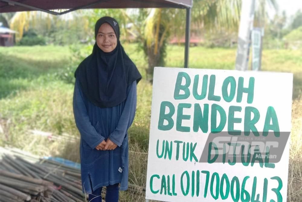 Rulita Sari menjual buluh bendera di hadapan rumahnya.