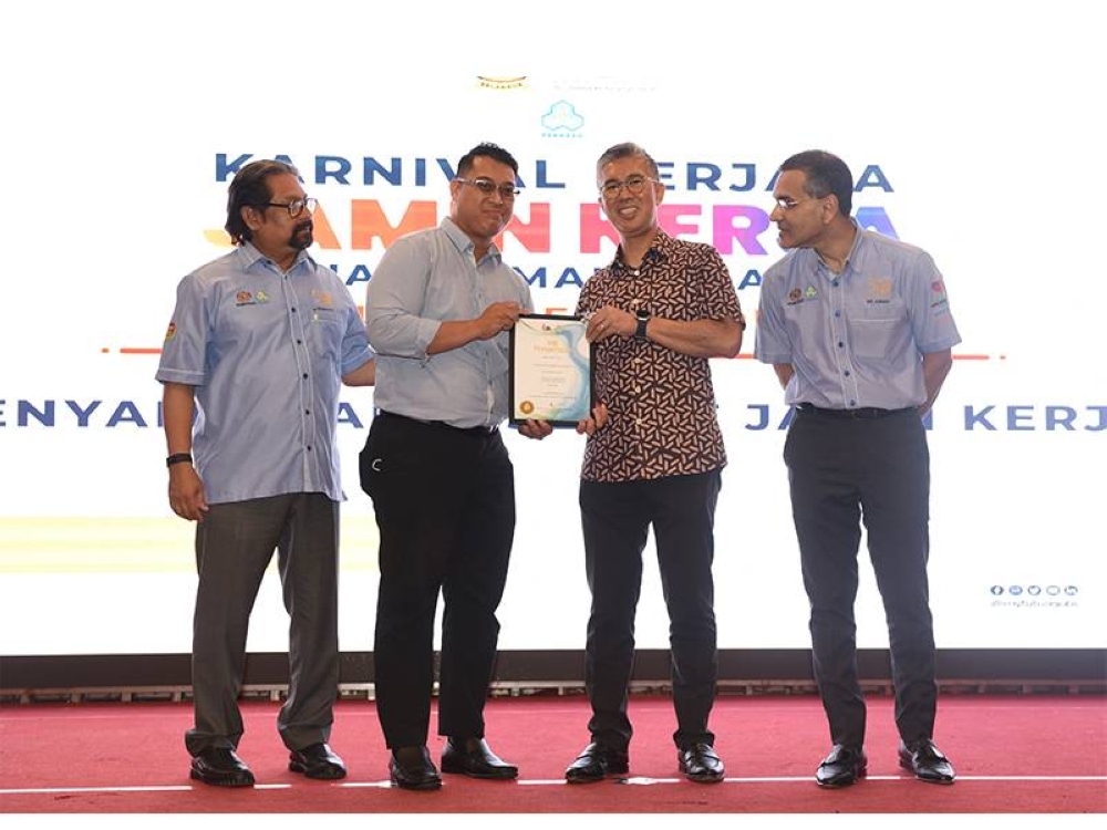 Tengku Zafrul menyampaikan sijil penghargaan kepada salah seorang majikan yang menyertai karnival kerjaya