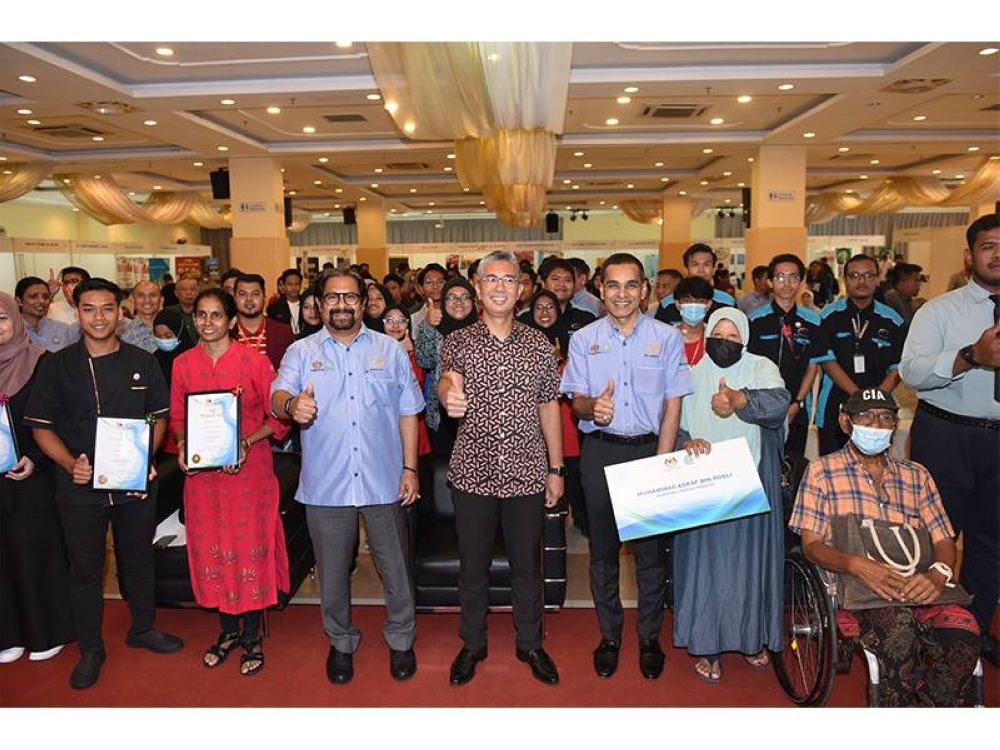 Tengku Zafrul (empat dari kanan) bergambar bersama penerima manfaat Perkeso pada Karnival Kerjaya Jamin Kerja Keluarga Malaysia pada Khamis.