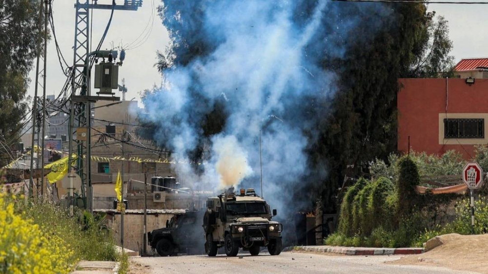 Sebuah file foto menunjukkan tentara Israel menembakkan gas air mata ke kamp pengungsi Jenin.  - foto AFP