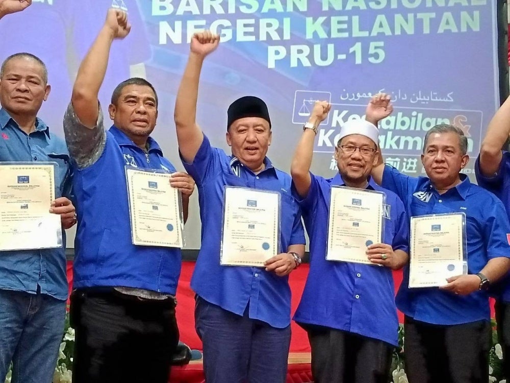 Ahmad Jazlan (tiga dari kiri) bersama Che Abdullah (dua dari kanan) dan calon-calon BN pada Majlis Penyerahan Watikah Calon BN Kelantan di Pejabat Perhubungan UMNO Kelantan di Kota Bharu, pada Jumaat.
