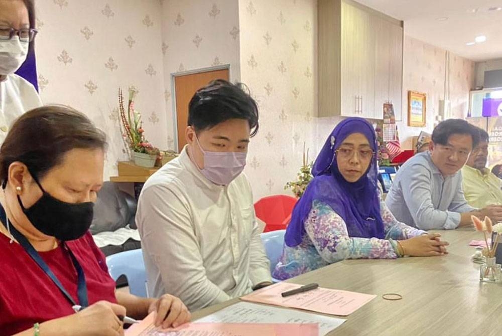 Sharifah Hazlina (dua kanan) dan Pau Yong membantu Bryan Yong (dua dari kiri) mengisi borang pencalonan di Bilik Gerakan Utama DUN Tronoh, di sini pada Jumaat.