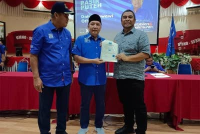 Datuk Ahmad Jazlan Yaakub (tengah) ketika menyampaikan watikah kepada 14 calon Parlimen BN di Pejabat Penerangan UMNO Kelantan