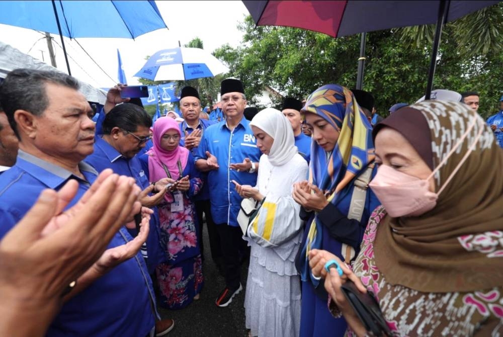 Annuar (empat dari kanan) yang datang memberikan sokongan dan membacakan doa kepada Marzuani Ardila (tiga dari kanan) di pusat penamaan calon di Parlimen Ketereh, Kota Bharu pada Sabtu.