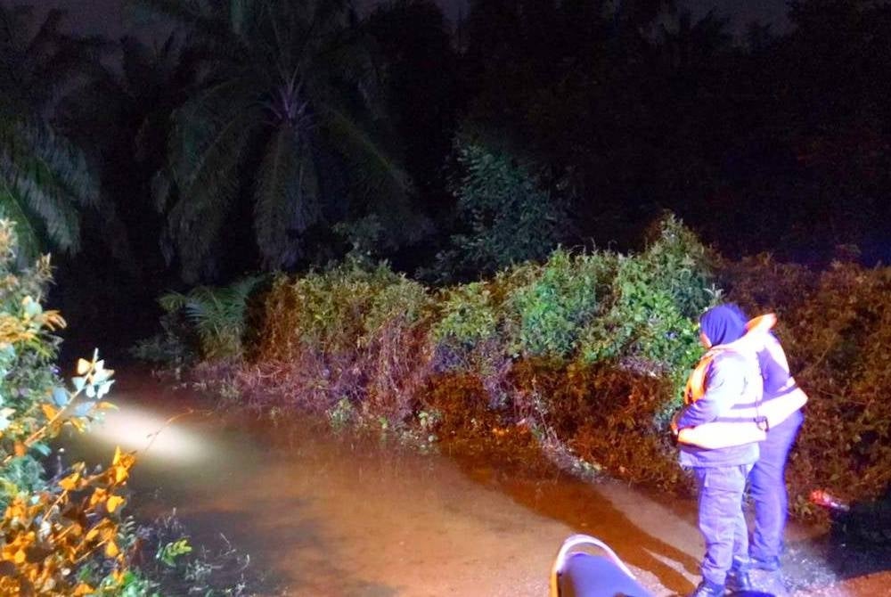 Anggota APM memeriksa laluan masuk ke Kampung Tok Deh di Rantau Panjang yang telah dinaiki air ekoran limpahan Sungai Golok. - Foto Ihsan APM