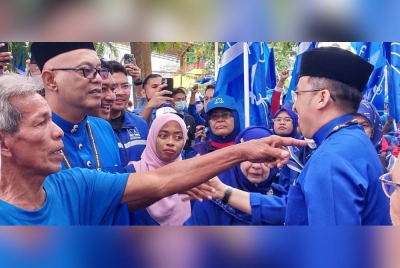 Asyraf Wajdi (kanan) bersalam dengan penyokong selepas keluar dari Pusat Penamaan Calon di Dewan Serbaguna Gerik.