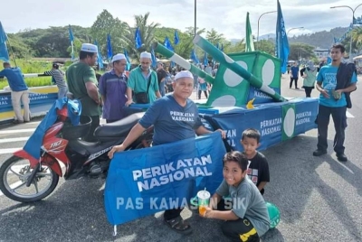 Orang ramai bergambar bersama replika 'kereta perisai' yang dibawa bagi memeriahkan hari penamaan calon di Parlimen Sik. - Foto FB Pas Kawasan Sik-Laman Rasmi