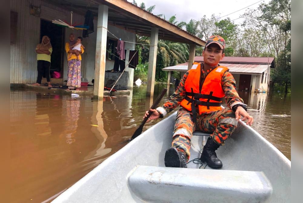 Bomba menggunakan perahu untuk menyelamatkan Norasila dan keluarga.