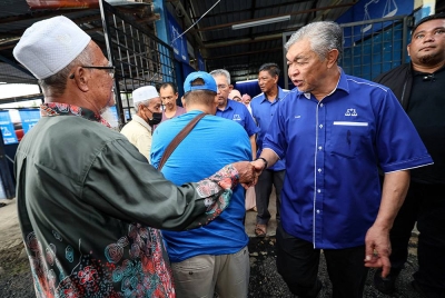Ahmad Zahid bersalaman bersama Jentera Pusat Daerah Mengundi (PDM) ketika hadir pada Program Sembang Santai di PDM Sungai Nipah Darat hari ini. Foto Bernama
