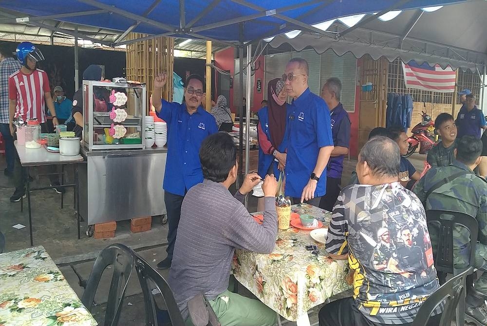 Aminudin (berdiri, kanan) ketika berkempen bersama-sama Mazlan di Batu 8, Hulu Kinta di sini pada Isnin.