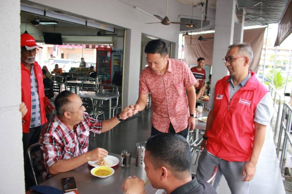 Chun Kuan (berdiri, dua dari kanan) bersama calon PH Parlimen Indera Mahkota, Zuraidi Ismail (kanan) beramah mesra bersama pelanggan sebuah restoran pada sesi 'walkabout' di sini pada Isnin.