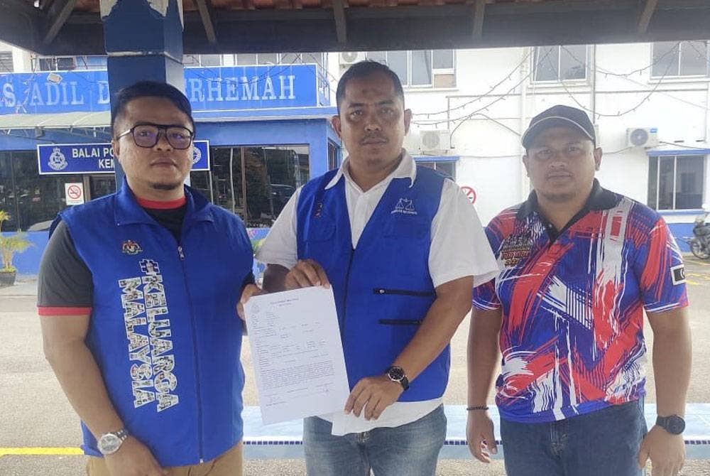 Hashim (tengah) menunjukkan laporan polis yang dibuat berhubung sepanduk yang menyerang peribadi Ahmad.