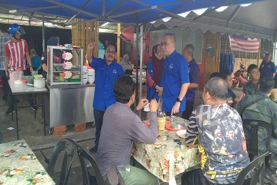 Aminudin (berdiri, kanan) ketika berkempen bersama-sama Mazlan di Batu 8, Hulu Kinta di sini pada Isnin.