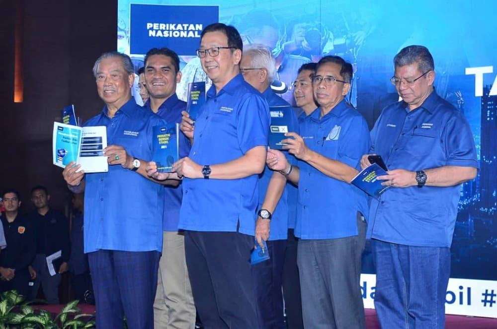 Muhyiddin (kiri) bersama pemimpin PN lain menunjukkan buku Tawaran PRU15 PN.