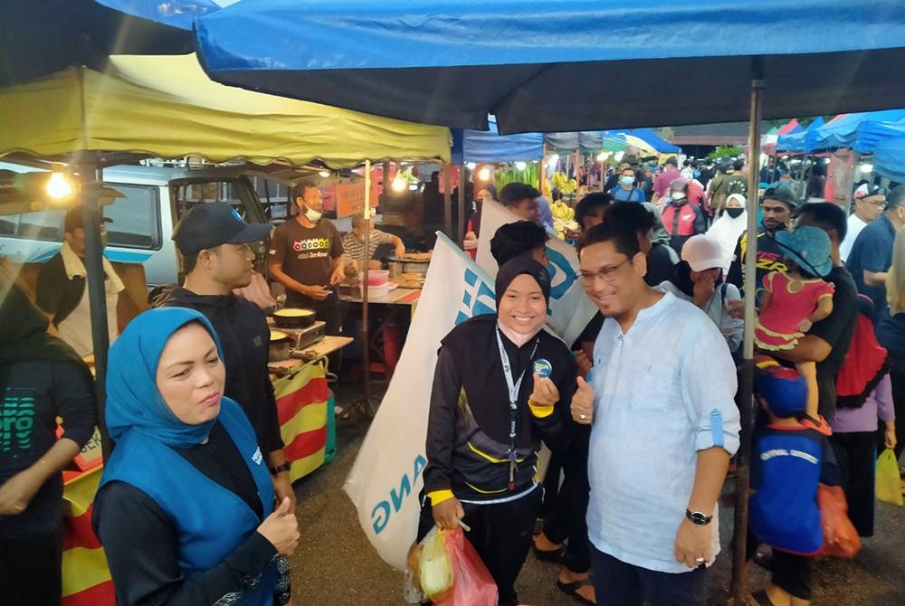 Ahmad Faizal (kanan) bertemu pengunjung pasar malam di Taman Perpaduan, di sini pada Selasa.