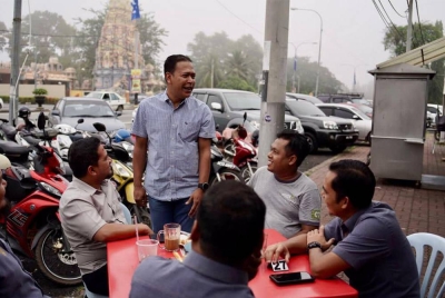 Hasmuni (berdiri) semasa menyantuni penduduk di Jitra pada pagi Selasa.