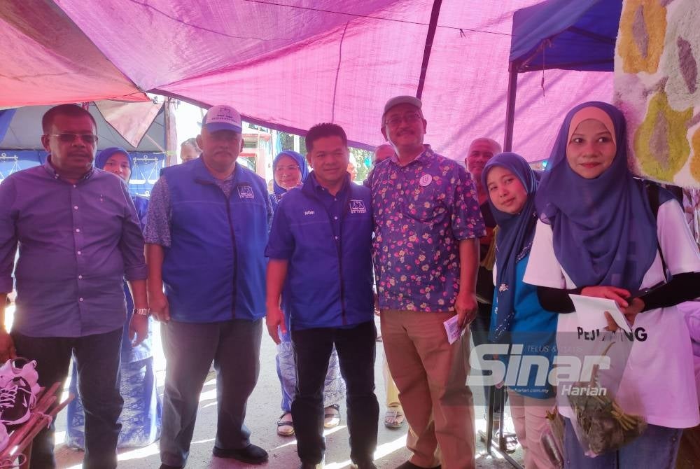 Nawi (tiga, kiri) bersama Wan Nazari (tiga, kanan) ketika bertembung di pasar pagi Kampung Alor Lintah, di sini pada Rabu.