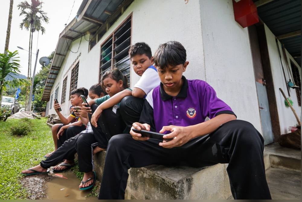 Kanak-kanak Orang Asli menikmati kemudahan jalur lebar yang baik di Kampung Orang Asli Kampung Sungai Chincin di Chenderiang. - Foto Bernama