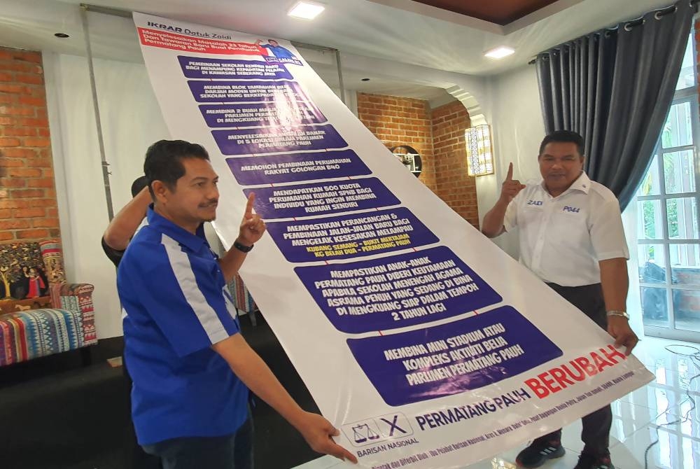 Mohd Zaidi (kanan) menunjukkan ikrar yang akan dilaksanakan olehnya sekiranya rakyat Permatang Pauh Berubah pada PRU15 kali ini.