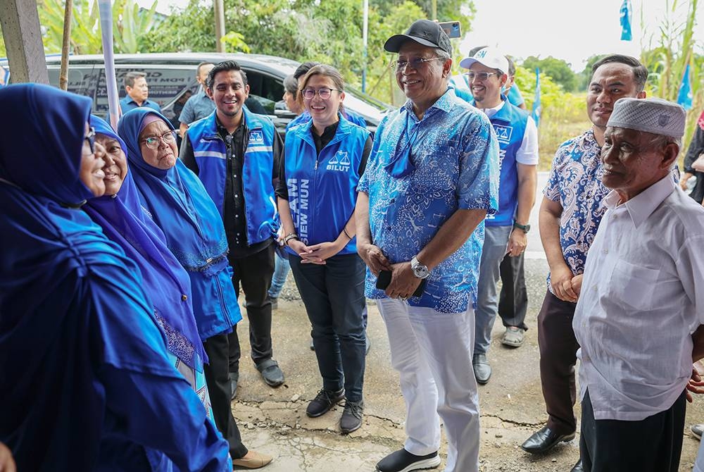 Annuar (tengah) bersama Siew Mun (lima dari kiri) beramah mesra dengan sebahagian jentera parti BN ketika melawat Bilik Gerakan BN Pusat Daerah Mengundi (PDM) Felda Lurah Bilut pada Rabu. - Foto Bernama