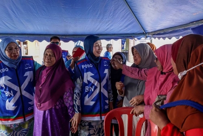 Muhaini beramah mesra bersama wanita-wanita UMNO ketika menghadiri Program Kenduri Rakyat di Felda Tembangan 2, Kemayang pada Khamis. - Foto Bernama