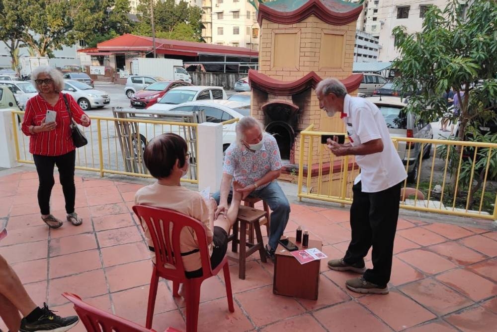 Ravinder (kanan) mendekati pengundi di sekitar Bayan Baru ketika mengadakan siri kempennya.