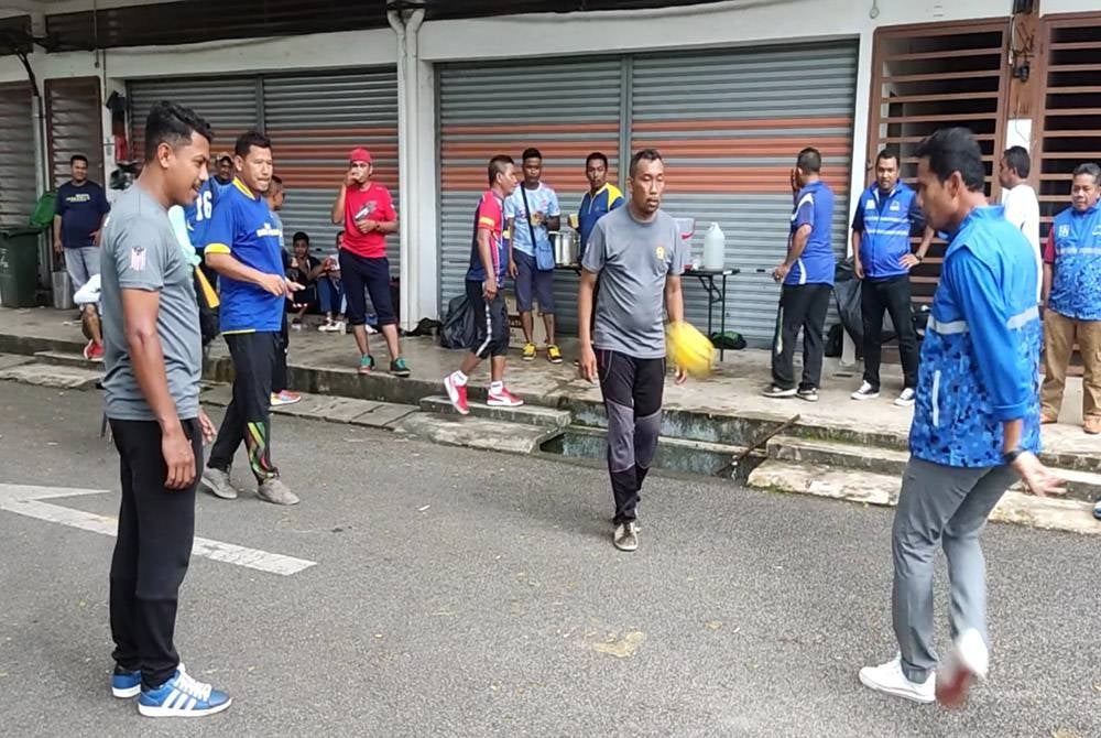 Noran Zamini (kanan) meluangkan masa bermain sepak raga padaProgram Kenduri Sepak Raga Taman Pinang Jaya, Bukit Pinang, dekat sini.