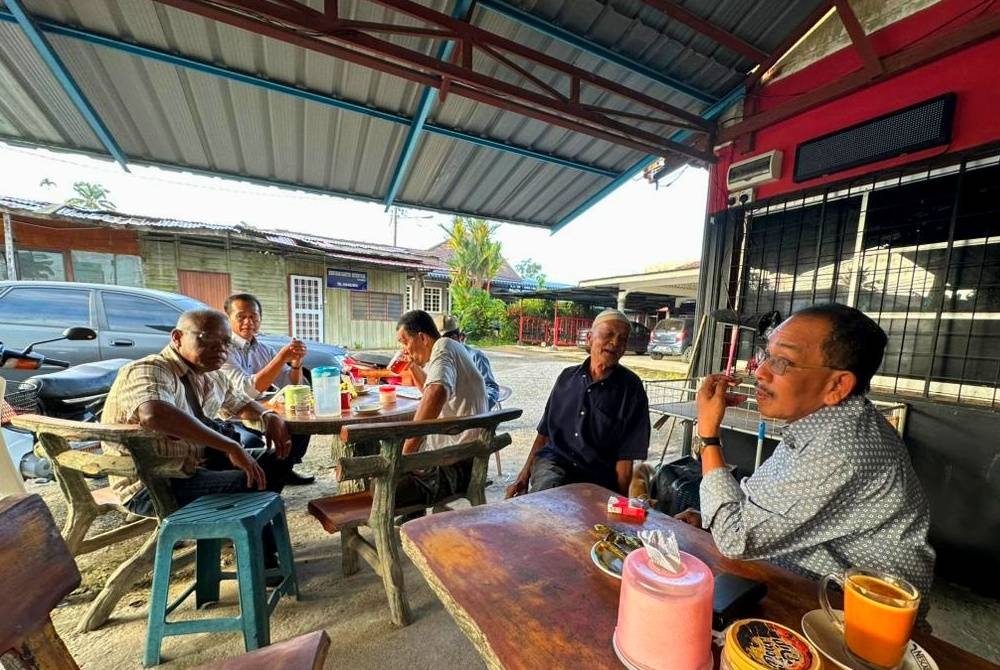 Calon PH Parlimen Tanah Merah, Mohamad Suparadi (kanan) memilih pendekatan berkempen di kedai kopi pada PRU15.