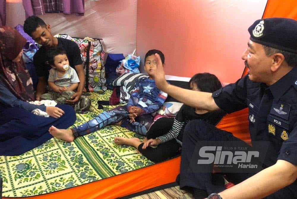 Muhamad Zaki (kanan) melawat mangsa banjir di SK Gual To’Deh, Rantau Panjang.