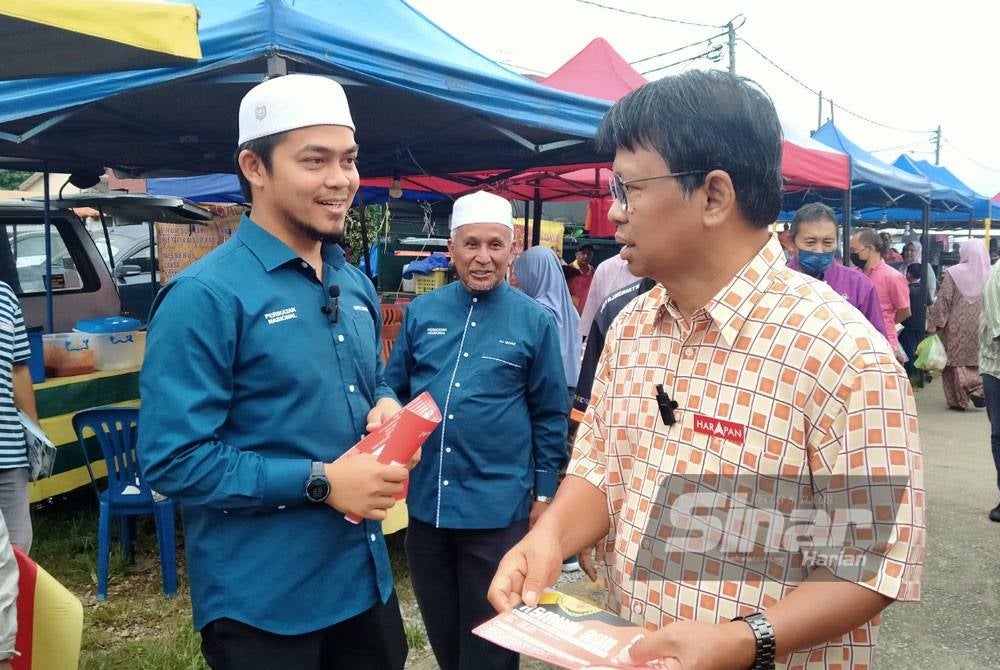 Asmuni (kanan) bertembung dengan Hafez apabila kedua-dua calon tersebut berkempen di Pasar Malam Taman Jati, di sini pada Jumaat.