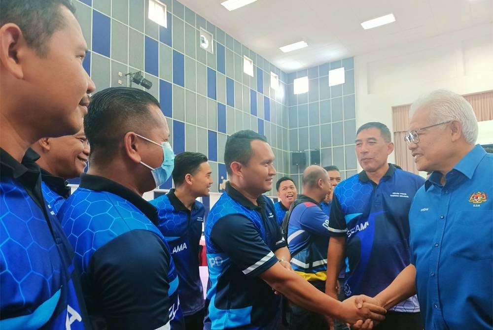 Hamzah (kanan) menyantuni pegawai dan anggota IPD Selama.