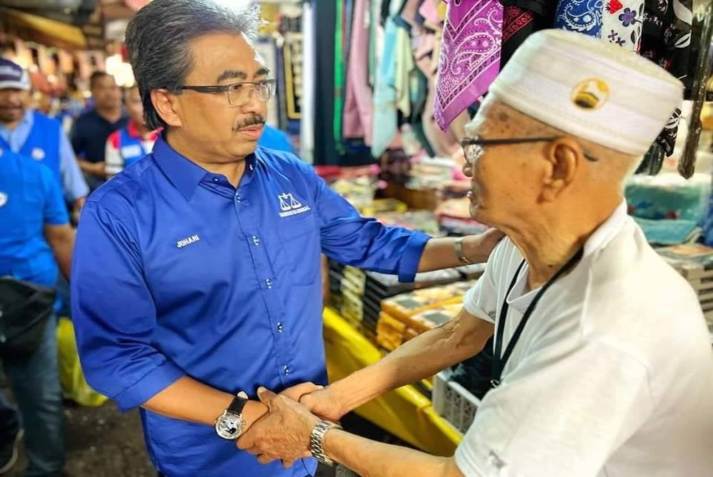 Johari (kiri) turun bertemu peniaga di Chow Kit pada sesi walkabout sempena kempen PRU15.Foto: FB Johari Abdul Ghani.