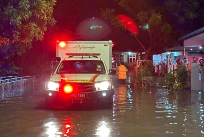 Anggota pasukan keselamatan memindahkan mangsa banjir ke PPS.