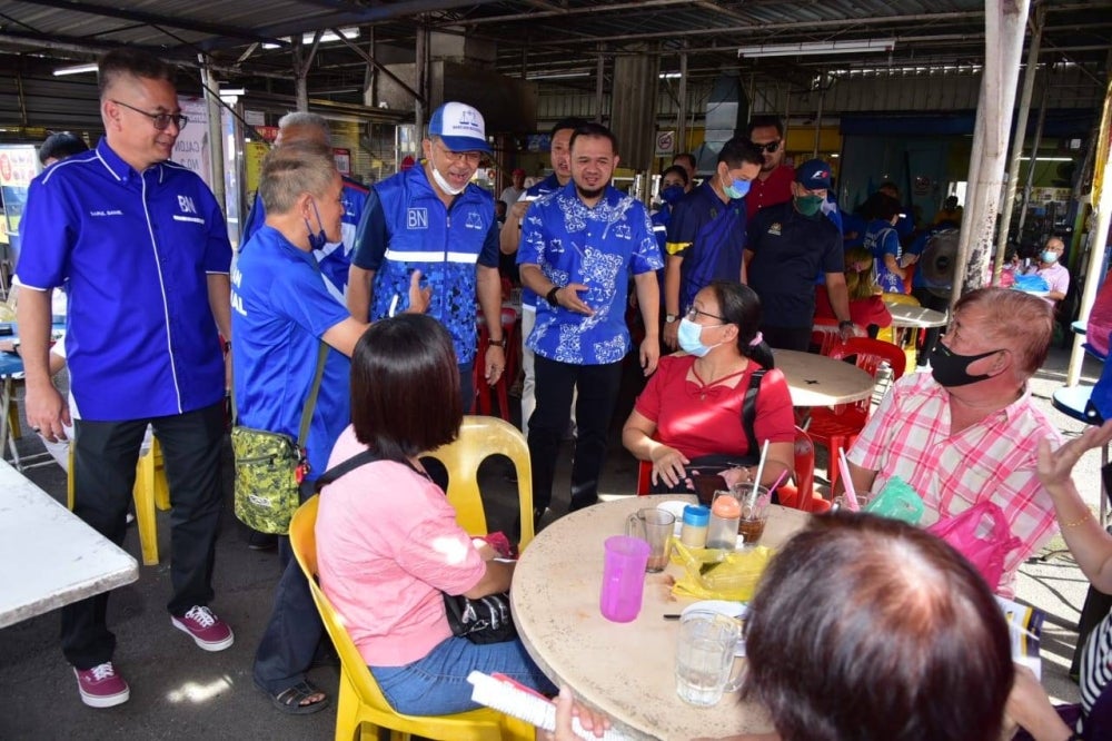 Azlan (dua kanan) bersama calon-calon BN Kangar beramah-mesra dengan orang ramai dalam program 'walkabout' pada Ahad.