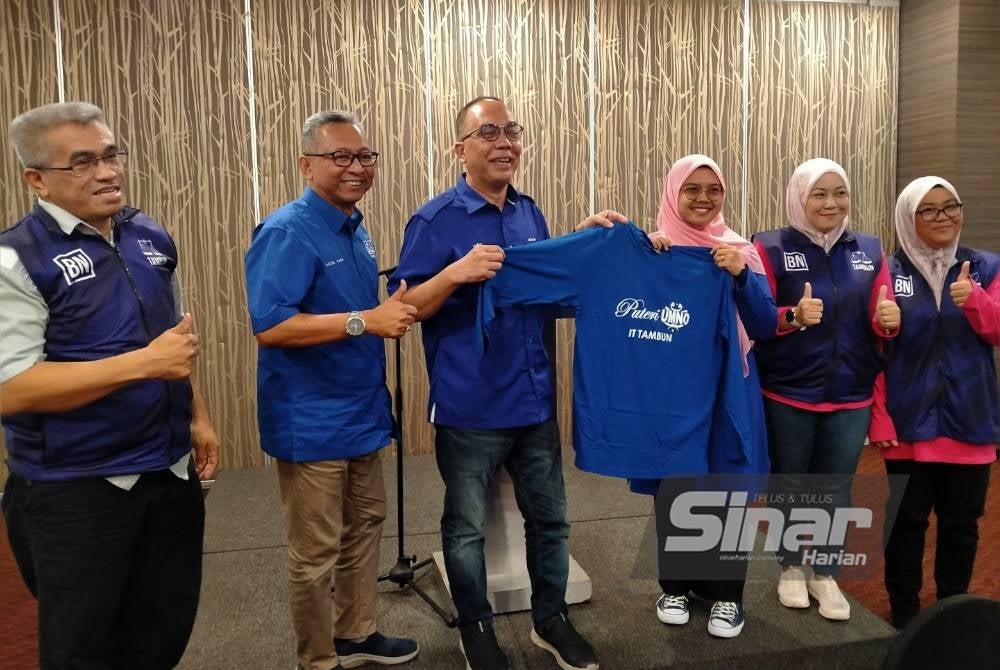 Aminuddin (tiga dari kiri) menerima t-shirt daripada Irmalini selepas mengadakan pertemuan dengan jentera teknologi maklumat (IT) Puteri UMNO Bahagian Tambun pada Ahad.
