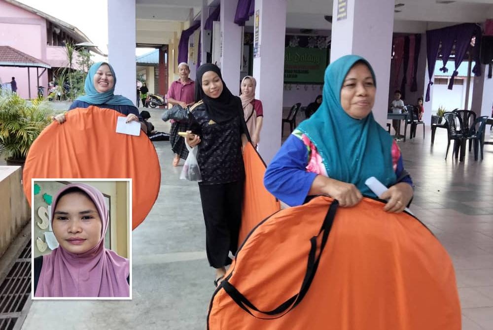 Norhashimah (depan) bersama anak-anak membawa khemah yang disediakan di PPS. (Gambar kecil: Amira)