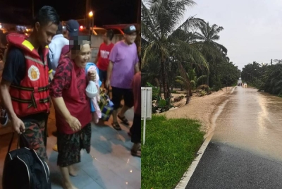 Anggota bomba memindahkan penduduk yang terjejas banjir di Kampung Baru Sengkang Kulai. Keadaan banjir di Sengkang, Kulai.- Foto Jabatan Bomba dan Penyelamat Malaysia.
