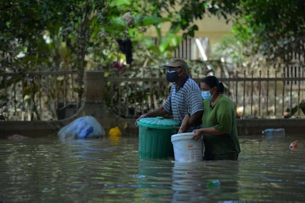 Dua beranak ini keluar mencari bantuan selepas bekalan makanan terputus akibat banjir.