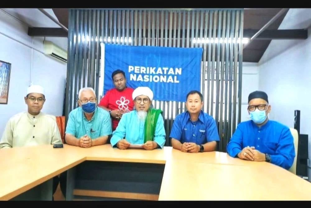 Muhammad Faudzi (tengah) menafikan dakwaan sepertimana tersebar pada kain rentang ketika di pejabat Bersatu Jelebu, petang Ahad.