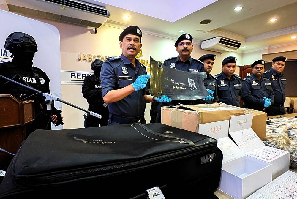 Sazali(kiri) menunjukkan pelapik getah yang dijadikan pelapik bagasi.