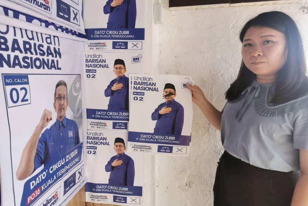 Phei Jin menunjukkan poster calon BN Parlimen Kuala Terengganu yang diconteng individu tidak bertanggungjawab.
