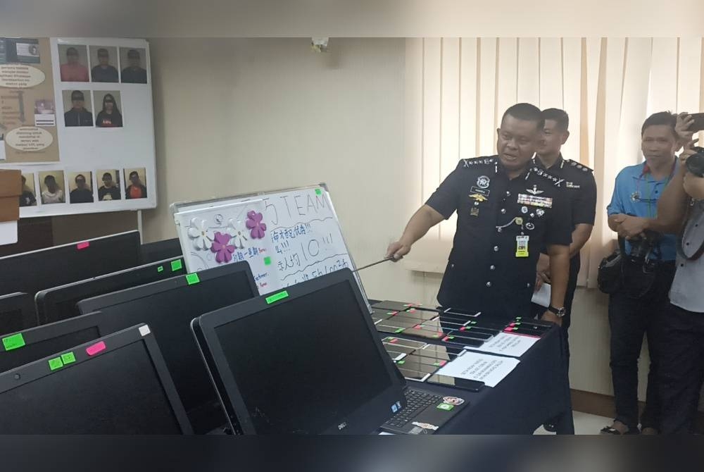 Kamarul Zaman menunjukkan peralatan komputer yang dirampas daripada sindiket penipuan tawaran kerja atas talian.