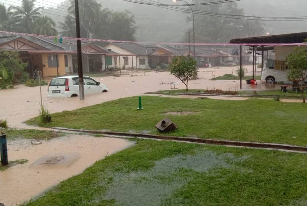 Sebuah kawasan perumahan di Sintok dinaiki air selepas hujan lebat empat jam pada petang Isnin. - Foto Netizen