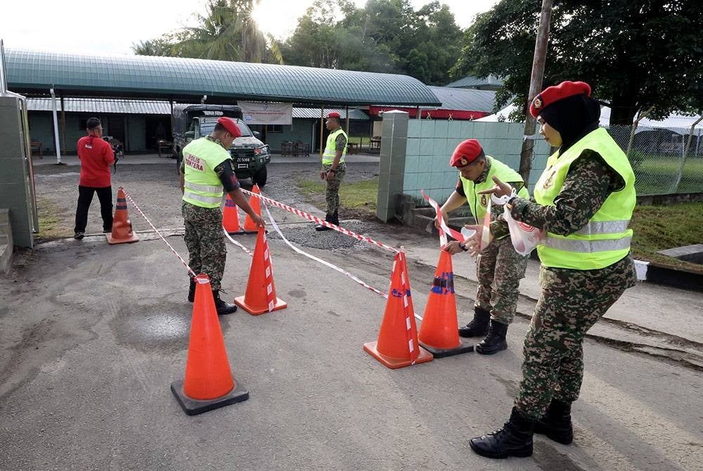 Anggota Tentera Darat Malaysia (ATM) Kem Lok Kawi membuat persiapan laluan ke tempat mengundi di Sekolah Agama Rakyat Kem Lok Kawi pada hari pengundian awal Pilihan Raya Umum (PRU15) hari ini.