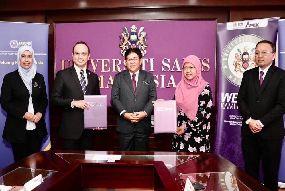 Pertukaran dokumen MoU antara Ahmad Dasuki (dua dari kiri) dan Dr. Narimah (dua dari kanan) pada majlis itu yang diadakan di USM Pulau Pinang pada Isnin.