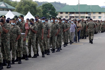 Anggota Tentera Darat Malaysia (ATM) Kem Lok Kawi berbaris menunggu giliran untuk mengundi awal di Sekolah Agama Rakyat Kem Lok Kawi. -Foto Bernama