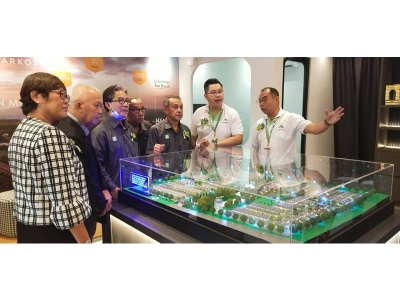 Alex (dua dari kanan) menunjukkan model projek perumahan kepada Idros (tiga dari kanan) dan tetamu yang hadir pada majlis perasmian galeri jualan Arkos di sini, pada Sabtu.