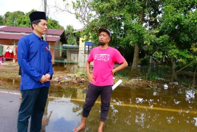 Dr Wan Shah Jihan (kiri) semasa turun padang bertanyakan khabar pada penduduk yang terlibat dengan masalah banjir termenung di Gual Tok Deh, Rantau Panjang pada Selasa.